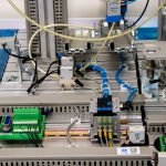 Detalhe de equipamento industrial com sensores e fiação eletrônica em uma instalação de fabricação.