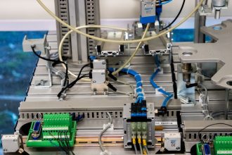 Detalhe de equipamento industrial com sensores e fiação eletrônica em uma instalação de fabricação.