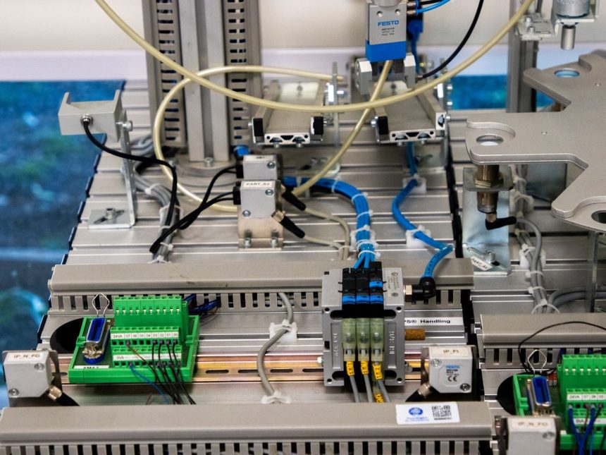 Detalhe de equipamento industrial com sensores e fiação eletrônica em uma instalação de fabricação.