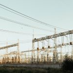 Subestação elétrica industrial ao ar livre, com torres e linhas de transmissão.
