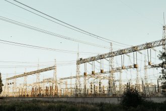Subestação elétrica industrial ao ar livre, com torres e linhas de transmissão.