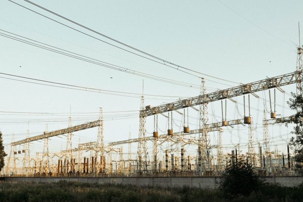 Subestação elétrica industrial ao ar livre, com torres e linhas de transmissão.