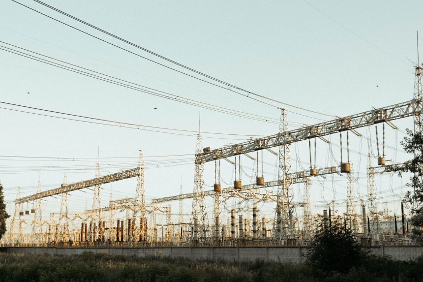 Subestação elétrica industrial ao ar livre, com torres e linhas de transmissão.